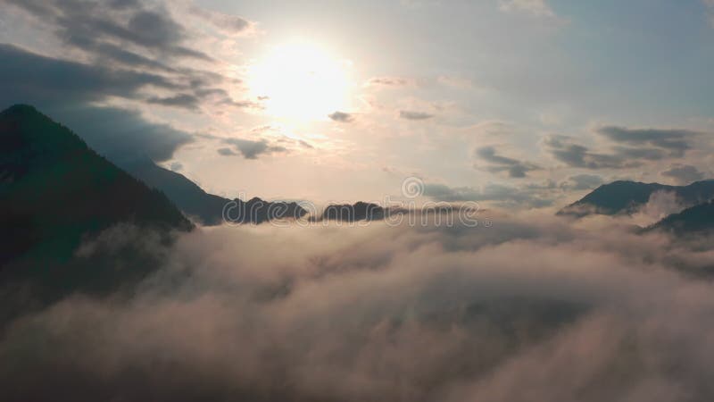 воздушный обзор заката или восхода солнца в горах над облаками