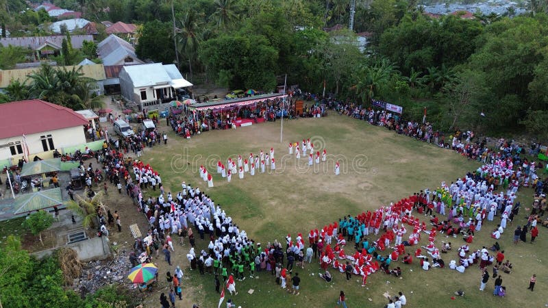 Aerial view of Indonesian flag lowering ceremony witnessed by villagers. Indonesia Independence Day. Aerial view of Indonesian flag lowering ceremony witnessed by villagers. Indonesia Independence Day.