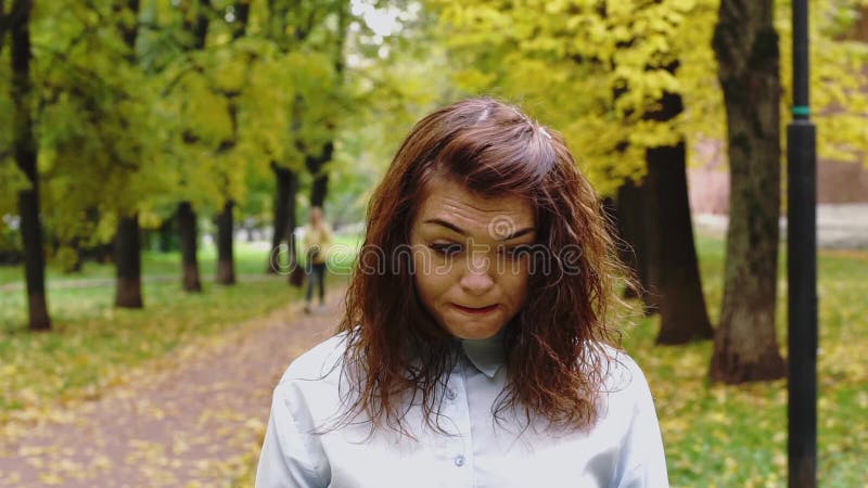Возмущённая молодая женщина redhead в парке акции видеоматериалы