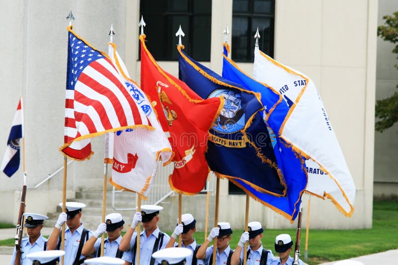 A USCG color guard carries the American flag and the flags representing the branches of the military. A USCG color guard carries the American flag and the flags representing the branches of the military.