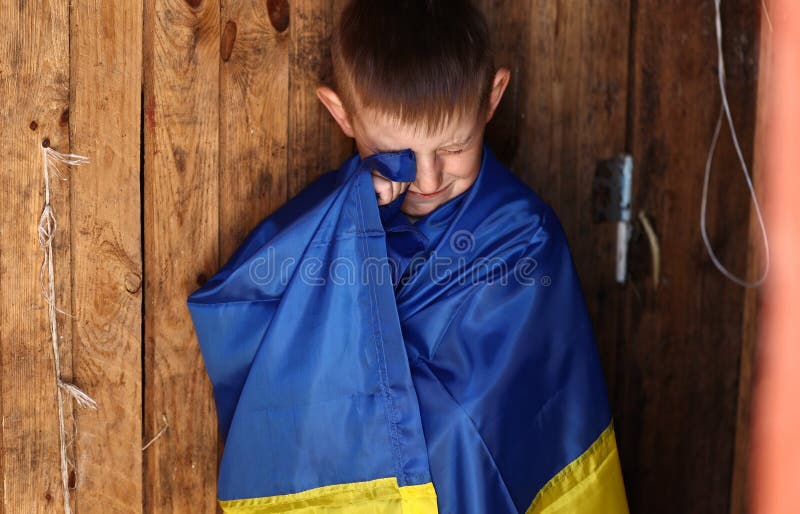 война против украины. плачущий украинский мальчик с флагом украины на свежем воздухе. остановить войну. антивоенный протест стоковое изображение