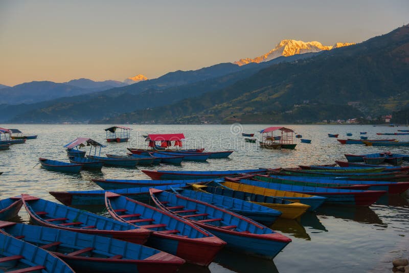 Восход солнца с деревянными шлюпками на озере Phewa, Pokhara, Непале стоковые изображения rf
