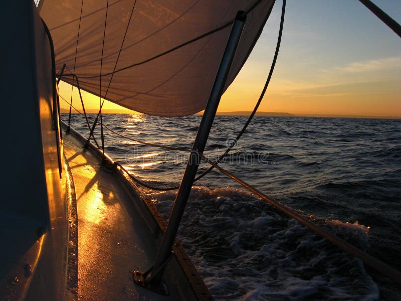 Watching a sunrise while under sail sailing in the Puget Sound. Watching a sunrise while under sail sailing in the Puget Sound