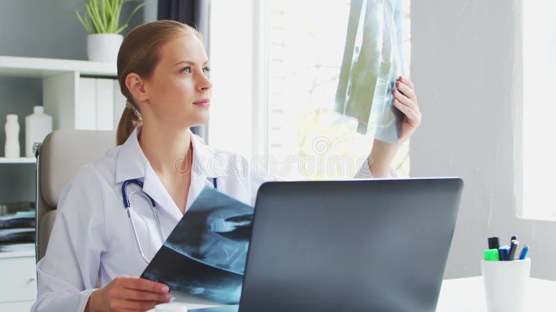 врач работает в медицинском учреждении. женщина в белом пальто. работа профессионального терапевта-женщины в больнице или видеоматериал