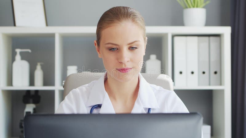 врач работает в медицинском учреждении. женщина в белом пальто. работа профессионального терапевта-женщины в больнице или сток-видео
