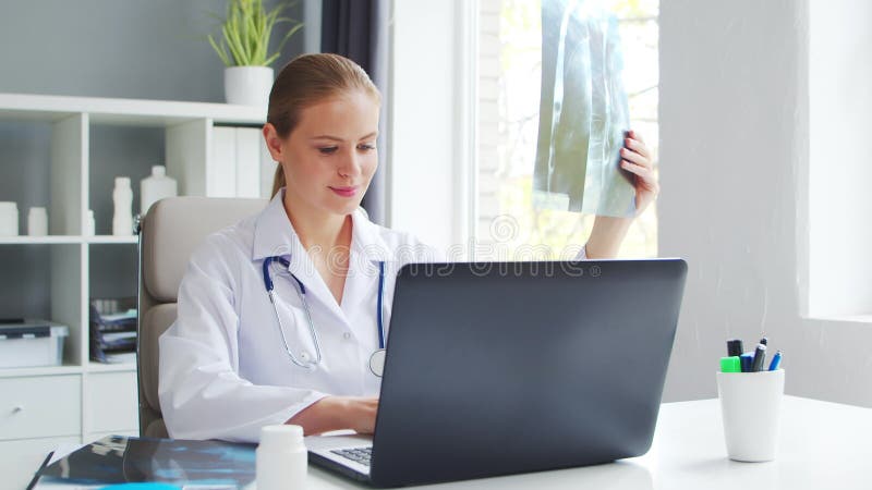 врач работает в медицинском учреждении. женщина в белом пальто. работа профессионального терапевта-женщины в больнице или сток-видео