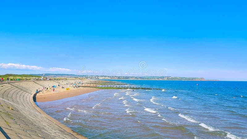 Dawlish Warren  Devon people packed on beach . still 1 hour for high tide  and they are all sitting tight together no more sand left to sit Dawlish Warren  Devon people packed on beach . still 1 hour for high tide  and they are all sitting tight together no more sand left to sit Dawlish Warren is located at the mouth of the Exe Estuary opposite Exmouth and has a beach, a National Nature Reserve spanning 506 acres &#x28;2 km2&#x29; and a golf course, which is classified as a Site of Special Scientific Interest. Dawlish Warren  Devon people packed on beach . still 1 hour for high tide  and they are all sitting tight together no more sand left to sit Dawlish Warren  Devon people packed on beach . still 1 hour for high tide  and they are all sitting tight together no more sand left to sit Dawlish Warren is located at the mouth of the Exe Estuary opposite Exmouth and has a beach, a National Nature Reserve spanning 506 acres &#x28;2 km2&#x29; and a golf course, which is classified as a Site of Special Scientific Interest