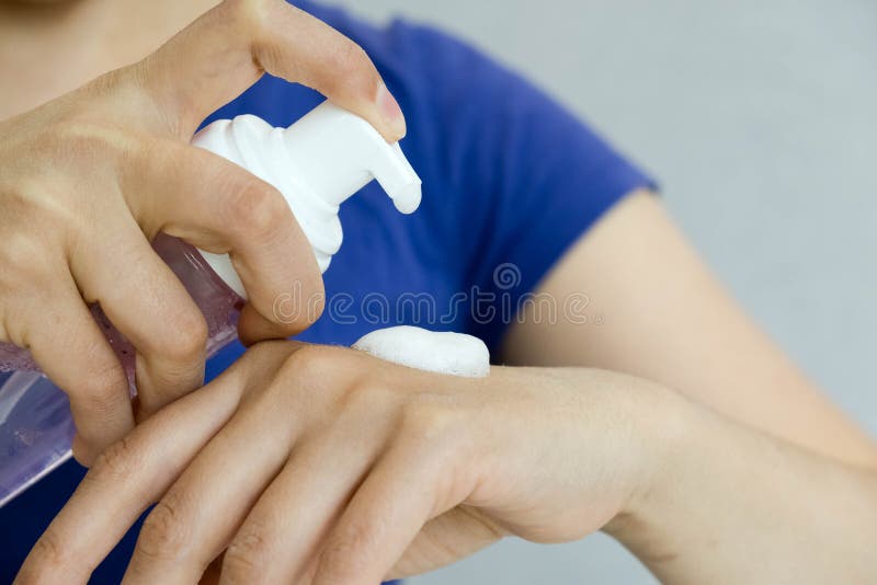 Вручите бутылку cleanser пены насоса прессы с предпосылкой ванной комнаты нерезкости концепция гигиены, мусса кладущ pomade в нал стоковое изображение rf Вручите бутылку cleanser пены насоса прессы с предпосылкой ванной комнаты нерезкости концепция гигиены, мусса кладущ pomade в нал стоковое изображение rf