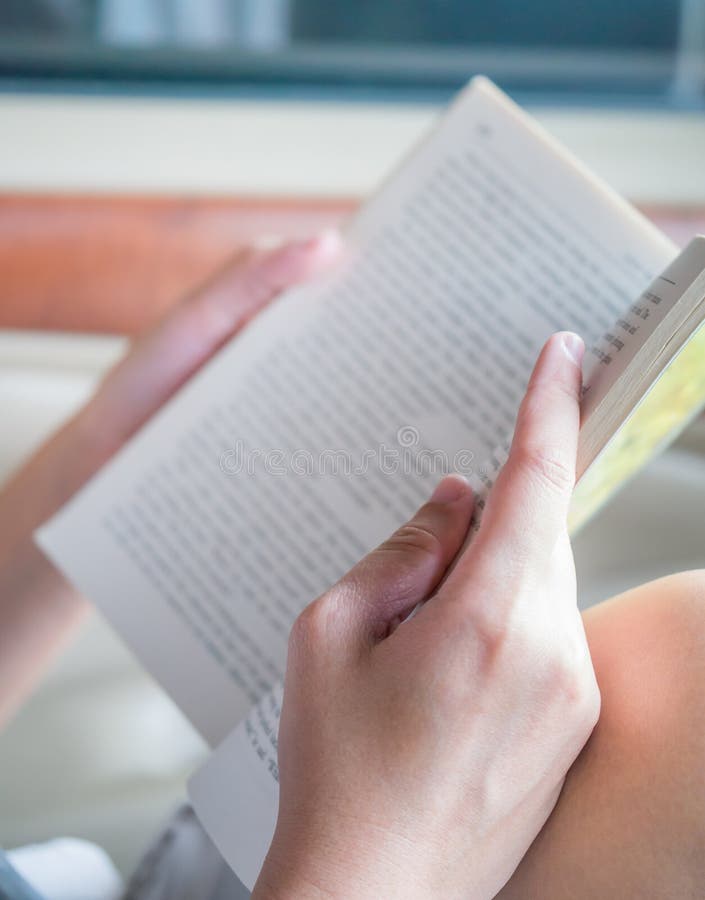 Вручите держать книгу для того чтобы прочитать пока сидящ в автомобиле стоковое изображение rf Вручите держать книгу для того чтобы прочитать пока сидящ в автомобиле стоковое изображение rf