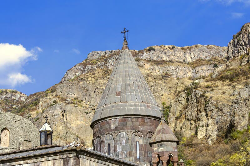 Все куполы с крестами и церковь пещеры с высекаенными khachkars на стенах, в монастыре Geghard в Армении стоковое изображение Все куполы с крестами и церковь пещеры с высекаенными khachkars на стенах, в монастыре Geghard в Армении стоковое изображение