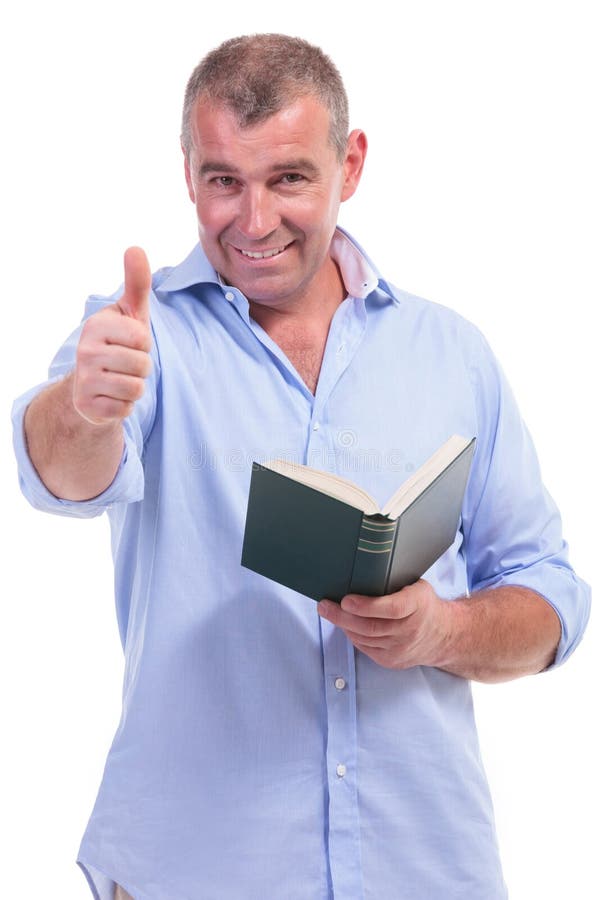 Вскользь человек постаретый серединой показывает о'кеы, с книгой стоковое изображение Вскользь человек постаретый серединой показывает о'кеы, с книгой стоковое изображение
