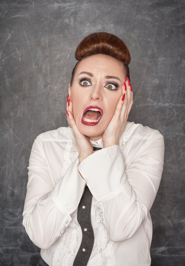 Scared teacher in white blouse on the blackboard background. Scared teacher in white blouse on the blackboard background