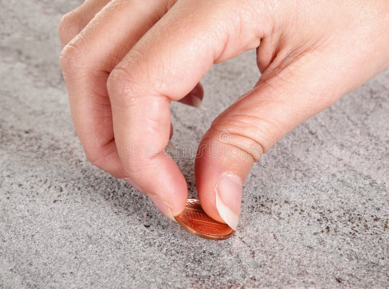Female hand finding a copper cent or money on a pavement. Female hand finding a copper cent or money on a pavement