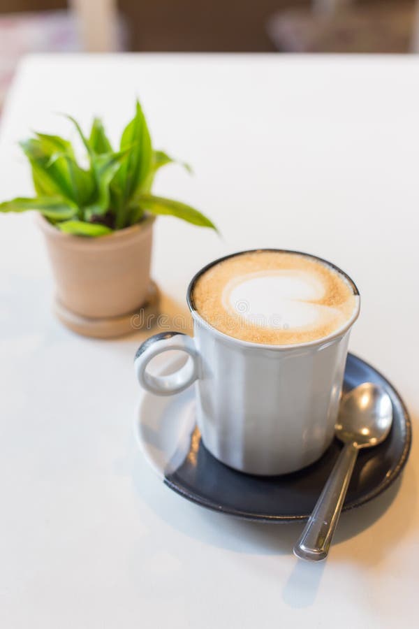 Выбранный кофе Latte искусства фокуса в чашке на деревянном столе стоковое фото Выбранный кофе Latte искусства фокуса в чашке на деревянном столе стоковое фото