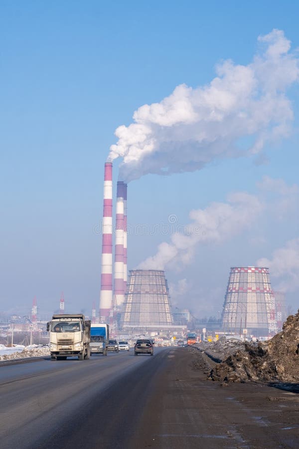 Naberezhnye Chelny, Russia, March 2, 2024. The factory is emitting smoke into the sky, polluting the air with gas. The building is located on an asphalt road surface, surrounded by vehicles. Naberezhnye Chelny, Russia, March 2, 2024. The factory is emitting smoke into the sky, polluting the air with gas. The building is located on an asphalt road surface, surrounded by vehicles