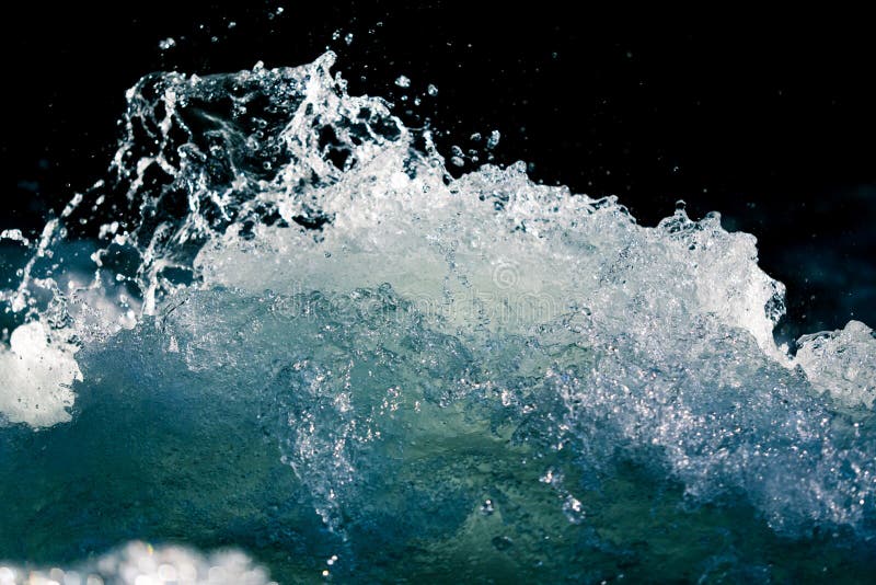 Выплеск бурной воды в океане на черной предпосылке стоковая фотография