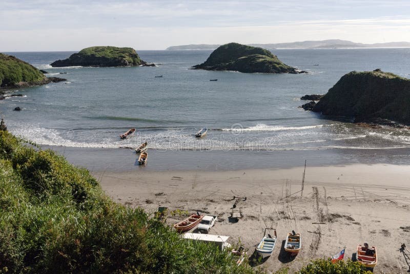 Высокая угловая снимок пляжа с маленькими лодками с острова chiloe в чили стоковые изображения