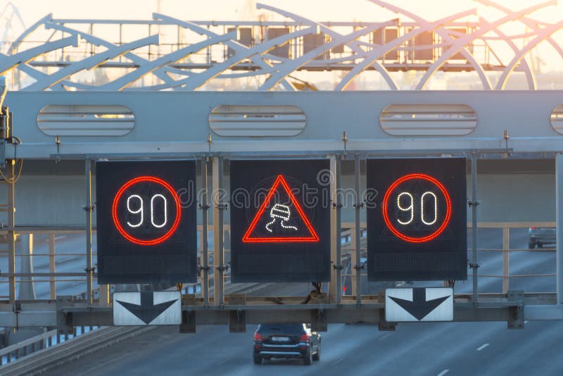 Высокоскоростное шоссе с автомобилями движения и электронными взаимодействующими знаками ограничения в скорости и скользким преду стоковые изображения rf Высокоскоростное шоссе с автомобилями движения и электронными взаимодействующими знаками ограничения в скорости и скользким преду стоковые изображения rf