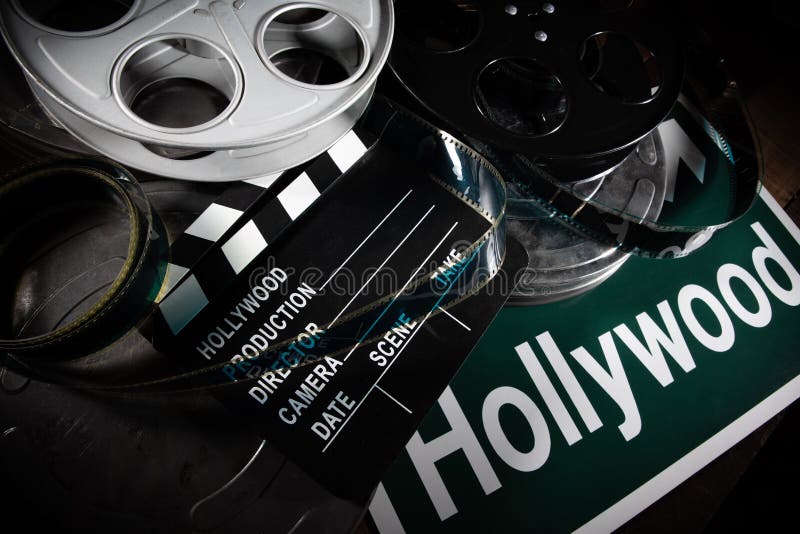 Вьюрок фильма и clapboard Голливуд, предпосылка индустрии развлечений на деревянной таблице стоковое фото rf Вьюрок фильма и clapboard Голливуд, предпосылка индустрии развлечений на деревянной таблице стоковое фото rf