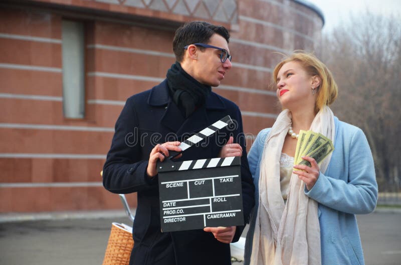 Гай и девушка с clapperboard и деньгами стоковое фото