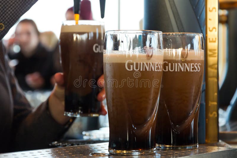 DUBLIN, IRELAND - FEB 15, 2014: Pints of beer are served at The Guinness Brewery on Feb 15, 2014. The brewery where 2.5 million pints of stout are brewed daily was founded by Arthur Guinness in 1759. DUBLIN, IRELAND - FEB 15, 2014: Pints of beer are served at The Guinness Brewery on Feb 15, 2014. The brewery where 2.5 million pints of stout are brewed daily was founded by Arthur Guinness in 1759.