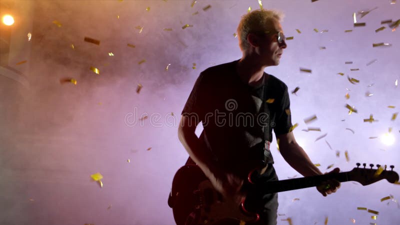 Гитарист выполняет на этапе Свет этапа, дым Сверху confetti падения золотой