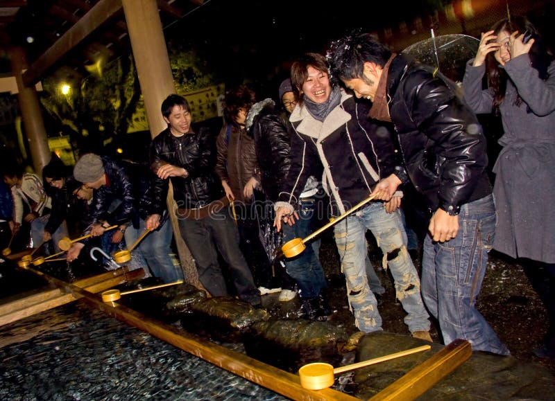 Japanese people in the temple at new year's eve. In the begining of a new year,Japanese people gathered to visit different shrines and pray for a good year.The event is called Hatsumode and it takes place between 1-4 January. Water-filled basins are used by worshipers for washing their hands, mouth and finally the handle of the water ladle to purify themselves before approaching the main Shinto shrine. Japanese people in the temple at new year's eve. In the begining of a new year,Japanese people gathered to visit different shrines and pray for a good year.The event is called Hatsumode and it takes place between 1-4 January. Water-filled basins are used by worshipers for washing their hands, mouth and finally the handle of the water ladle to purify themselves before approaching the main Shinto shrine.