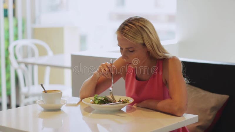 Голодная женщина есть салат для обеда на ресторане