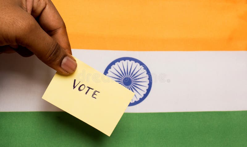 Voting concept - Person holding Hand Written Voting Sticker on India Flag. Voting concept - Person holding Hand Written Voting Sticker on India Flag.