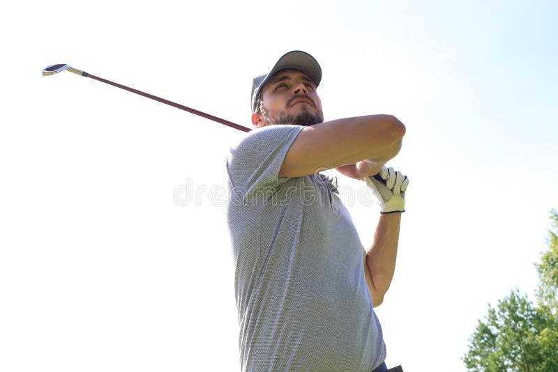 Golfer hits an fairway shot towards the club house. Golfer hits an fairway shot towards the club house.