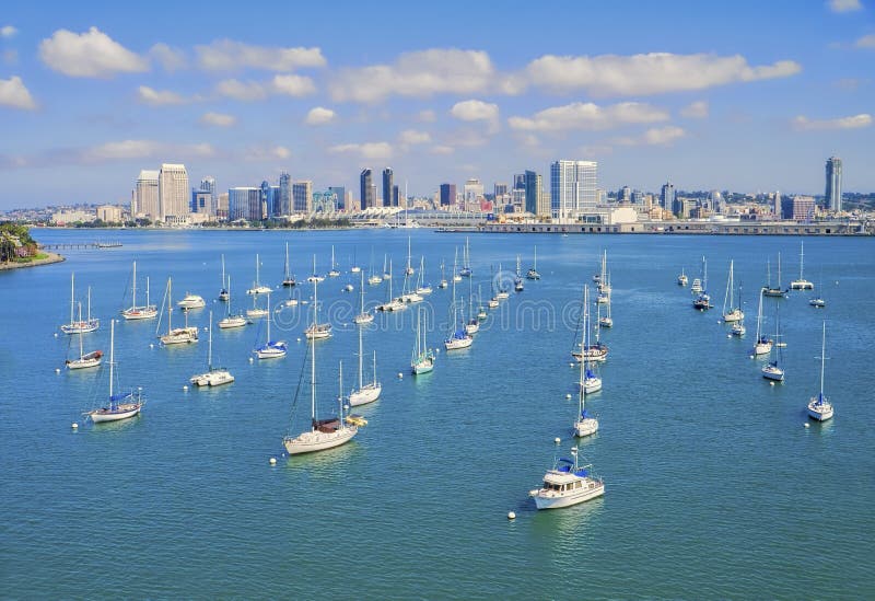 Small sail boats in a marina located in the city of Coronado, provide a foreground to the skyline panoramic vista of the downtown area of San Diego, southern California. Small sail boats in a marina located in the city of Coronado, provide a foreground to the skyline panoramic vista of the downtown area of San Diego, southern California.