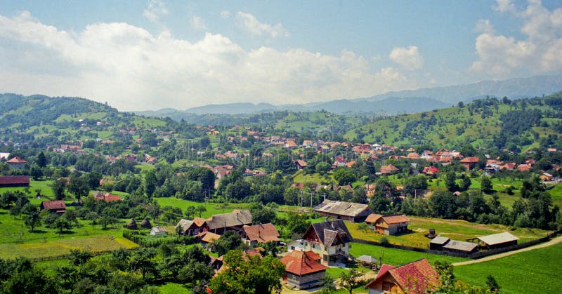 Landscape of mountainous village surrounded by lush forested hills. Film scan. Landscape of mountainous village surrounded by lush forested hills. Film scan.