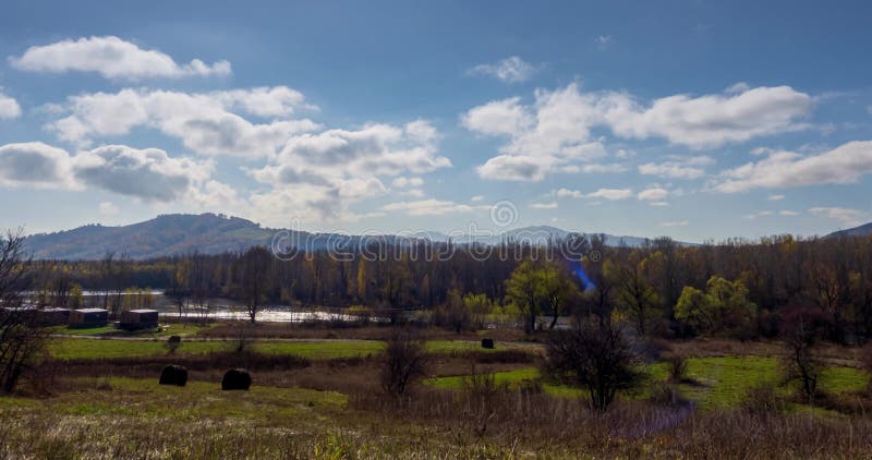 горное луговое время на осеннем закате. дикая природа и сельскохозяйственные стоки на травяном поле. вечернее туманное солнце