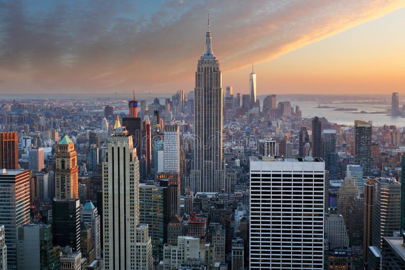 New York City. Manhattan downtown skyline with illuminated Empire State Building and skyscrapers at sunset. New York City. Manhattan downtown skyline with illuminated Empire State Building and skyscrapers at sunset.