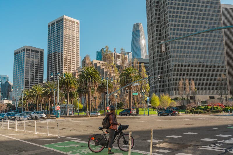 San Francisco, California, April 8, 2024. Urban street scene at The Embarcadero with cyclists and pedestrians, flanked by high-rise buildings and palm trees. San Francisco, California, April 8, 2024. Urban street scene at The Embarcadero with cyclists and pedestrians, flanked by high-rise buildings and palm trees