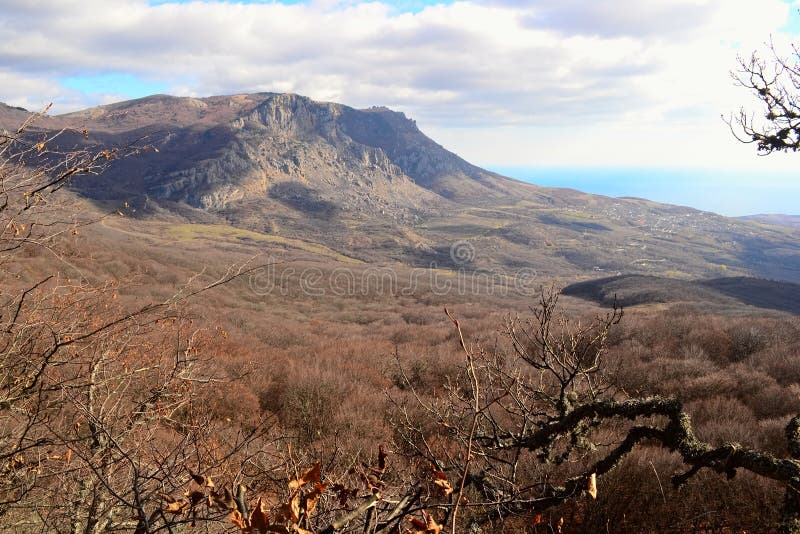 Горы в осени, облачном небе и море на предпосылке стоковое изображение Горы в осени, облачном небе и море на предпосылке стоковое изображение