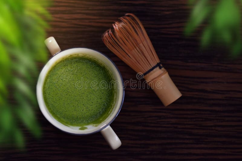 Горячая чашка Latte зеленого чая Matcha на деревянном столе с Chasen или бамбуковым венчиком Японский традиционный напиток Запачк стоковое изображение Горячая чашка Latte зеленого чая Matcha на деревянном столе с Chasen или бамбуковым венчиком Японский традиционный напиток Запачк стоковое изображение