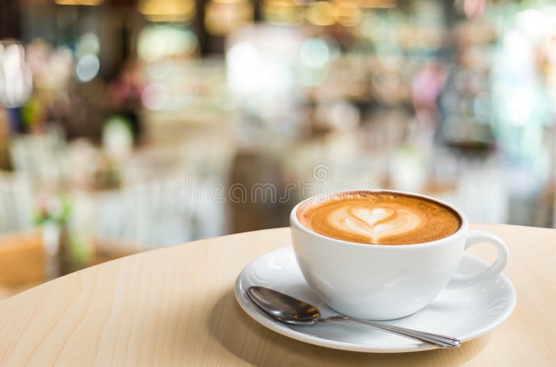 Горячий кофе Latte искусства в чашке на деревянном столе и кофейне bl стоковые фото Горячий кофе Latte искусства в чашке на деревянном столе и кофейне bl стоковые фото