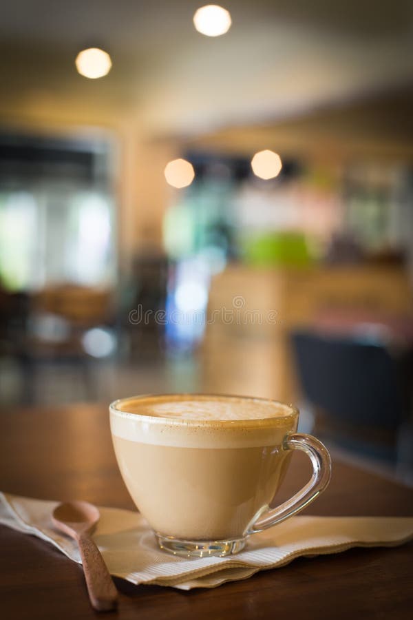 Горячий кофе Latte искусства в чашке на деревянном столе и кофейне bl стоковые фотографии rf Горячий кофе Latte искусства в чашке на деревянном столе и кофейне bl стоковые фотографии rf