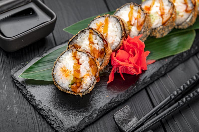 горячий рулон темпуры с лососем и сыром традиционный вкусный свежий суши рулон, расположенный на черном фоне