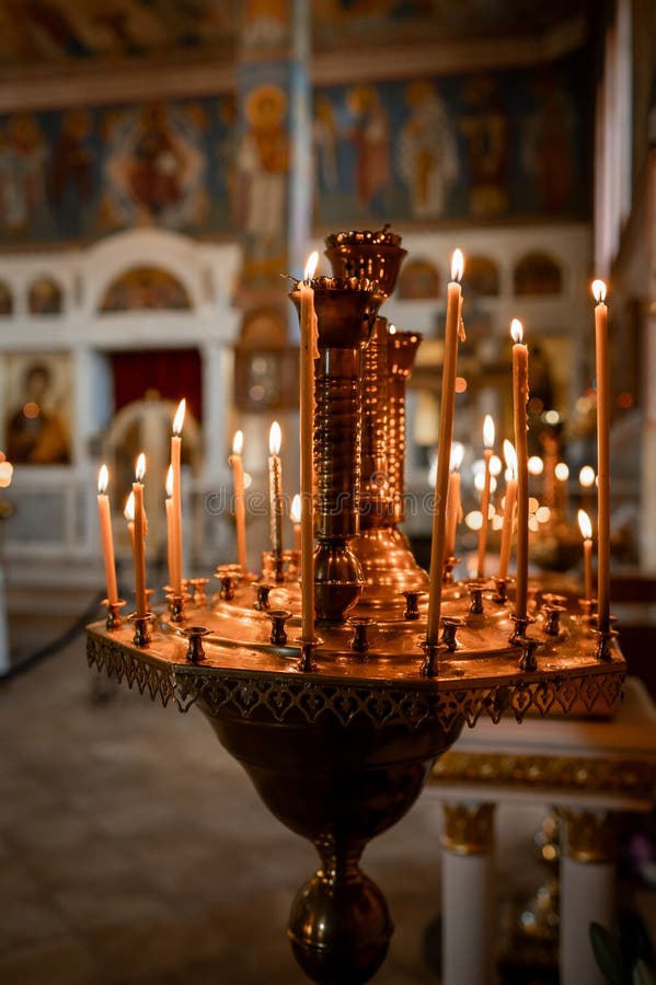 горящие свечи в золотом светильнике в православном храме стоковое фото