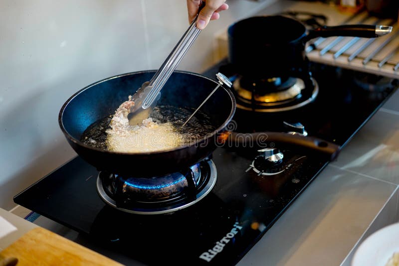Готовить блюда из свинины, жареную котлету японского tonkatsu во время повара на нефть тепла в кастрюле. стоковая фотография