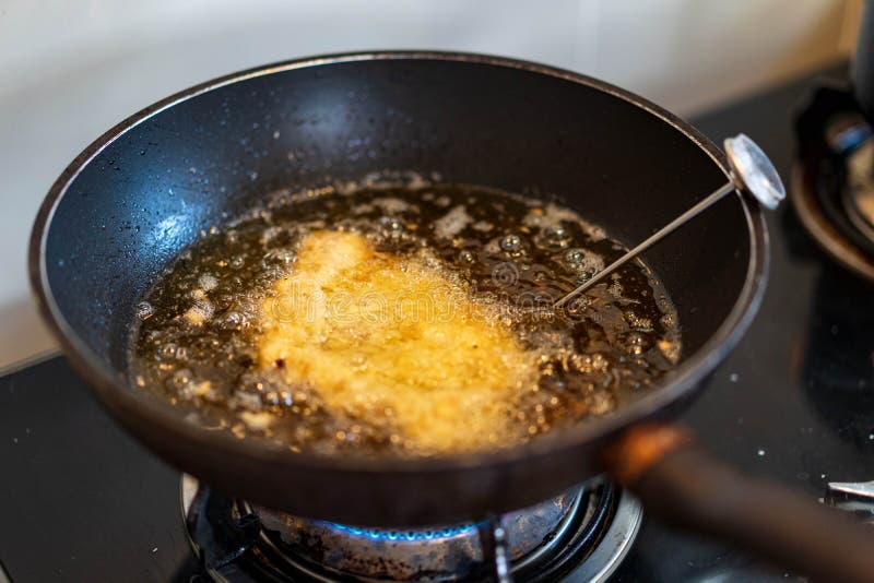 Готовить блюда из свинины, жареную котлету японского tonkatsu во время повара с помощью инструмента температуры на нефть тепла в к стоковые изображения