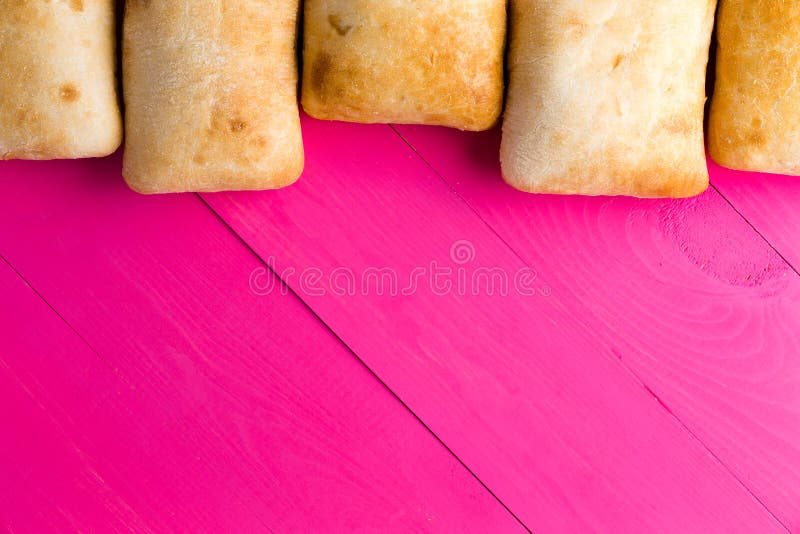 Граница итальянского хлеба ciabatta на экзотическом пинке стоковая фотография Граница итальянского хлеба ciabatta на экзотическом пинке стоковая фотография