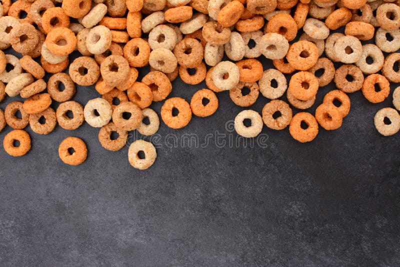 Граница хлопий для завтрака обручей Multigrain на темном сером шифере стоковое фото rf Граница хлопий для завтрака обручей Multigrain на темном сером шифере стоковое фото rf