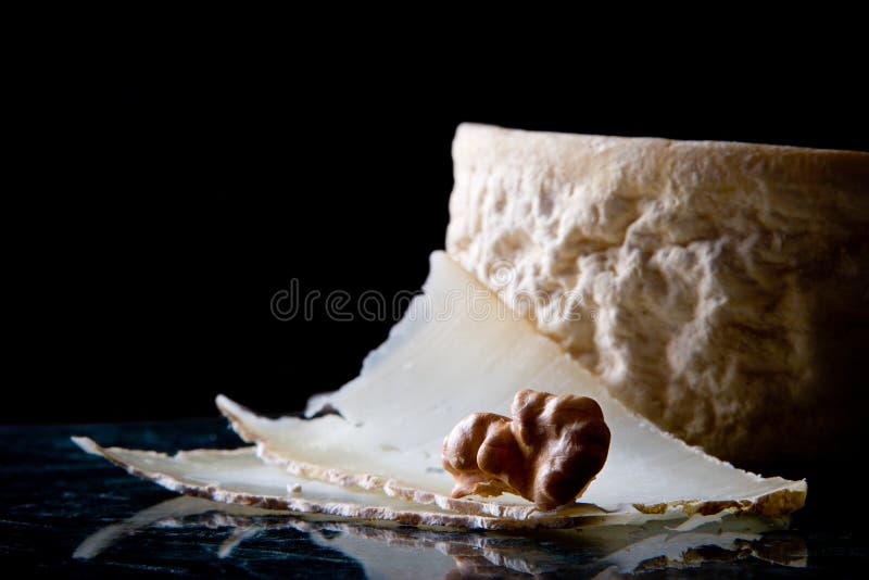 Goat cheese and walnut on black background. Goat cheese and walnut on black background