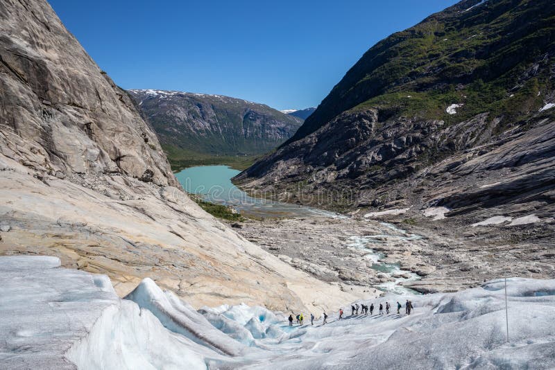 Группа в составе hiker ледника идя вниз с ледника на солнечный день Показывать исследование и весьма возможность спорта стоковые изображения Группа в составе hiker ледника идя вниз с ледника на солнечный день Показывать исследование и весьма возможность спорта стоковые изображения