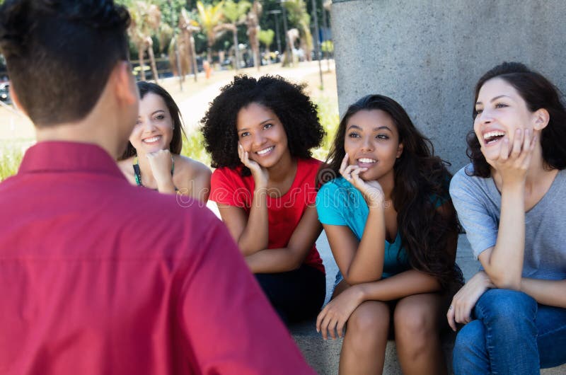 Группа в составе multi этнические девушки flirting с одним парнем стоковое изображение rf Группа в составе multi этнические девушки flirting с одним парнем стоковое изображение rf