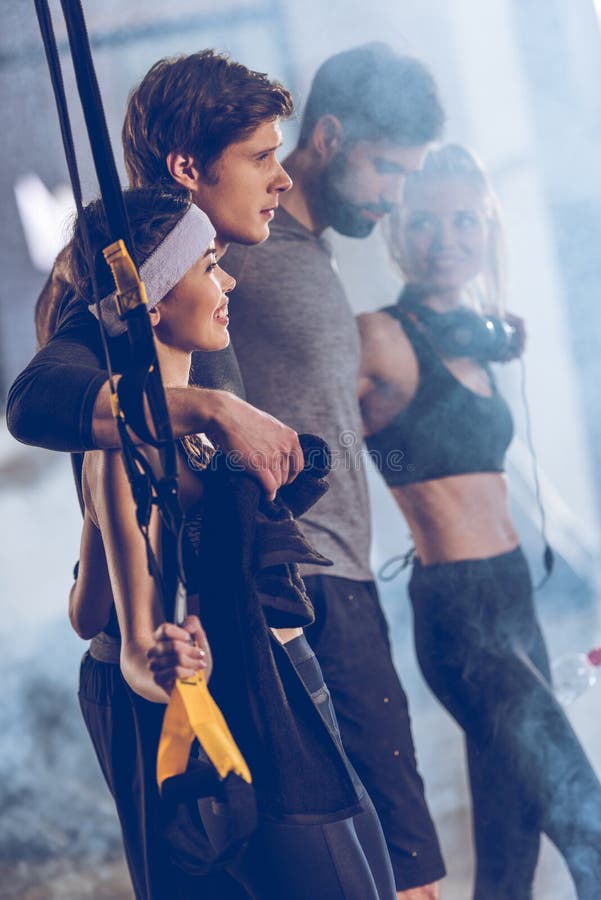 Группа в составе sportive люди приближает к оборудованию trx в спортзале стоковые фото Группа в составе sportive люди приближает к оборудованию trx в спортзале стоковые фото