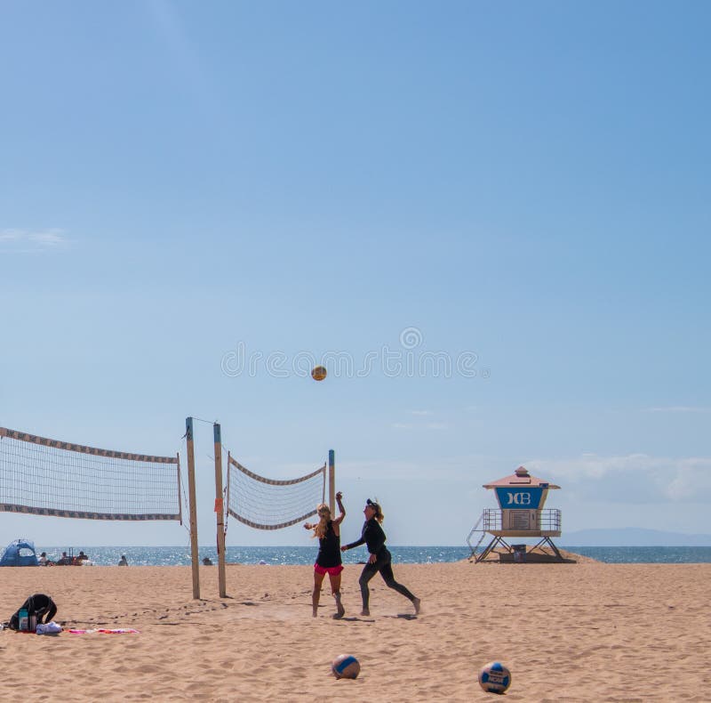 Группа в составе женщины играя волейбол на пляже на Huntington Beach, Калифорния стоковые фотографии rf Группа в составе женщины играя волейбол на пляже на Huntington Beach, Калифорния стоковые фотографии rf